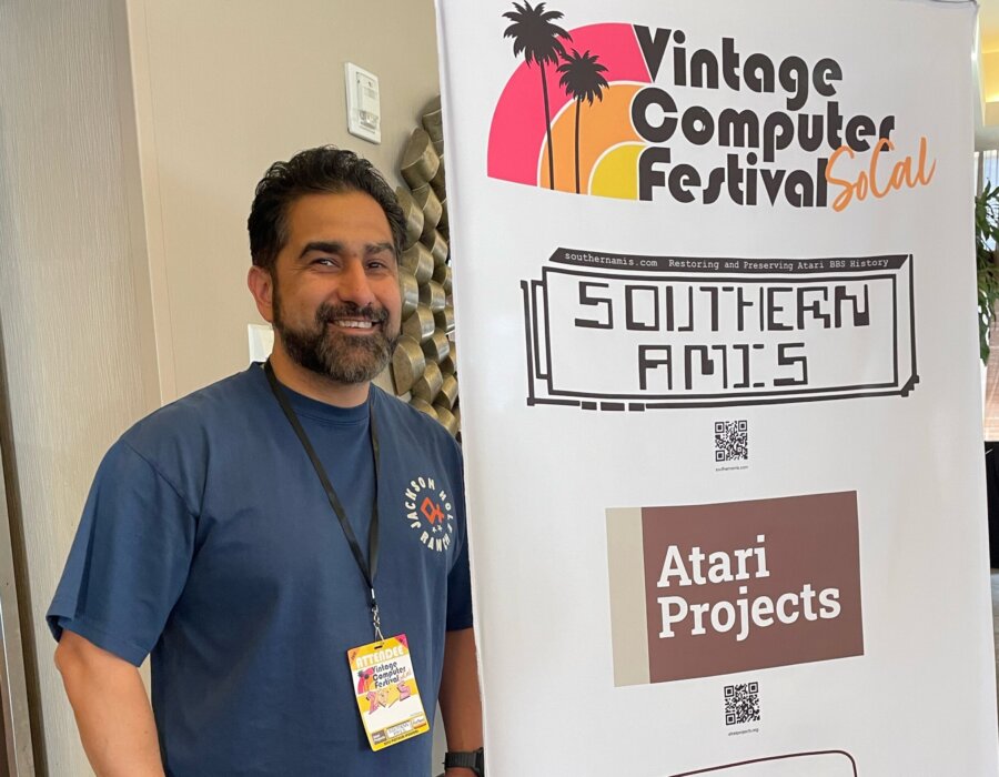 Man standing by signage for Vintage Computer Festival 2025